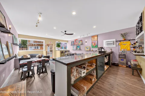 a kitchen with stainless steel appliances kitchen island granite countertop a table chairs and a stove