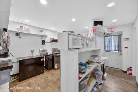 a kitchen with a sink dishwasher and a refrigerator with wooden floor