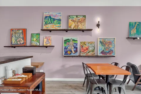 a dining room with furniture and painting on the wall