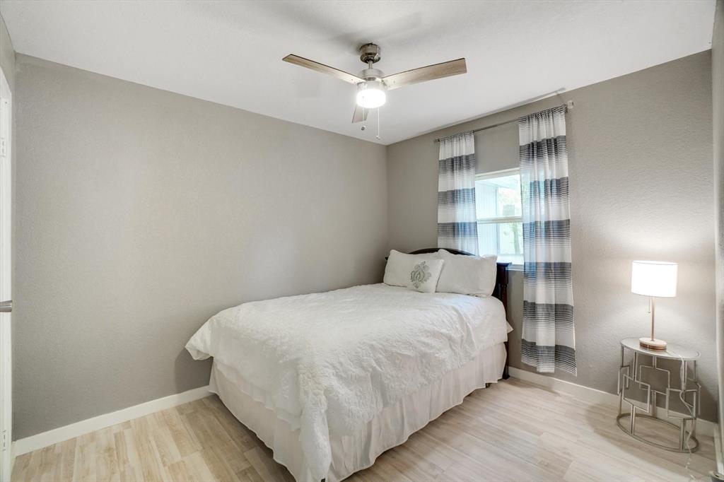 624 Apache Trail Tool, TX 75143 - Photo 13 of 21 a bedroom with a bed and a lamp on table with wooden floor