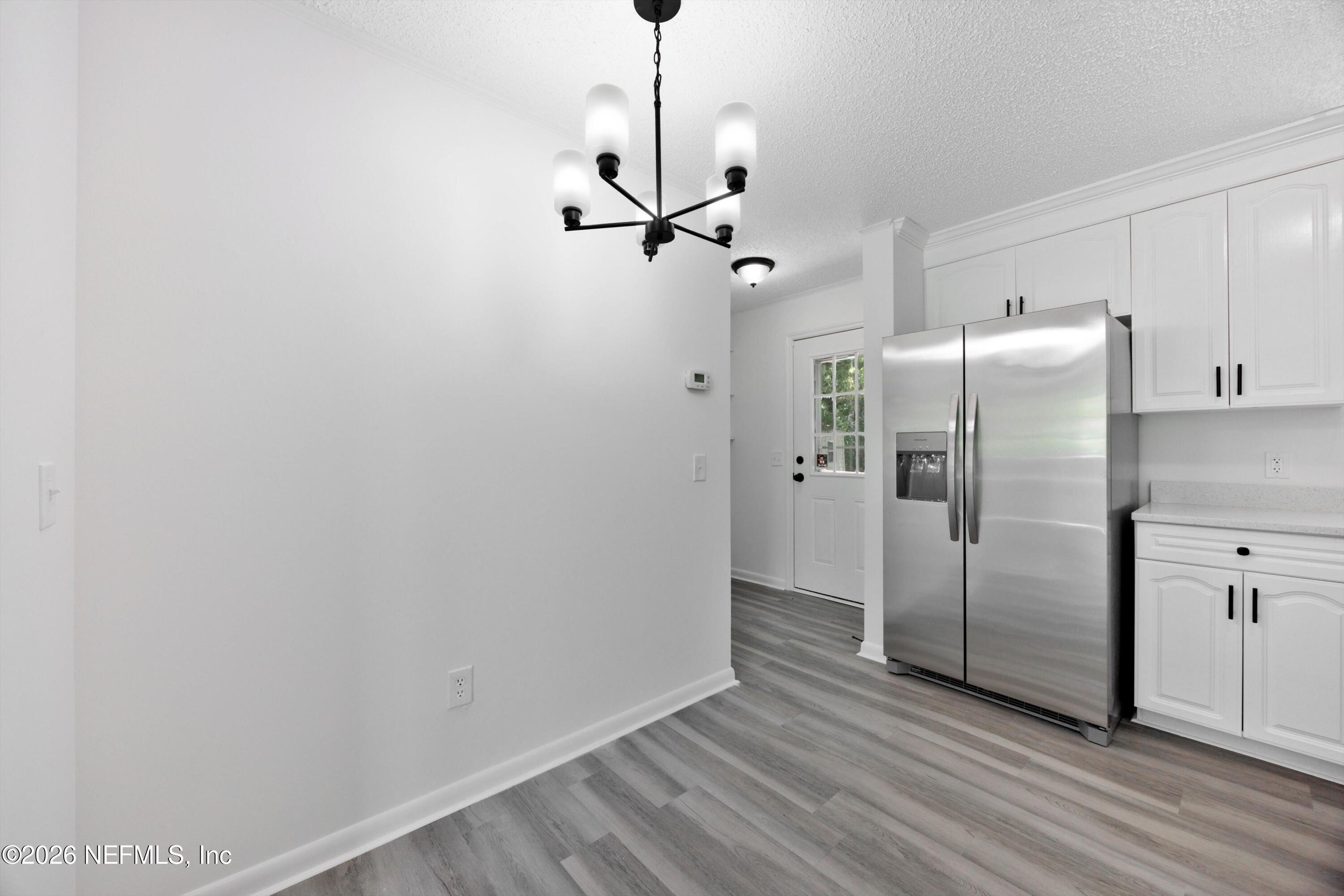 900 Helen Street St. Augustine, FL 32084 - Photo 11 of 31 a view of a kitchen with a refrigerator a ceiling fan and wooden floor