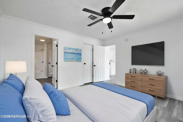 an empty room with wooden floor and a ceiling fan