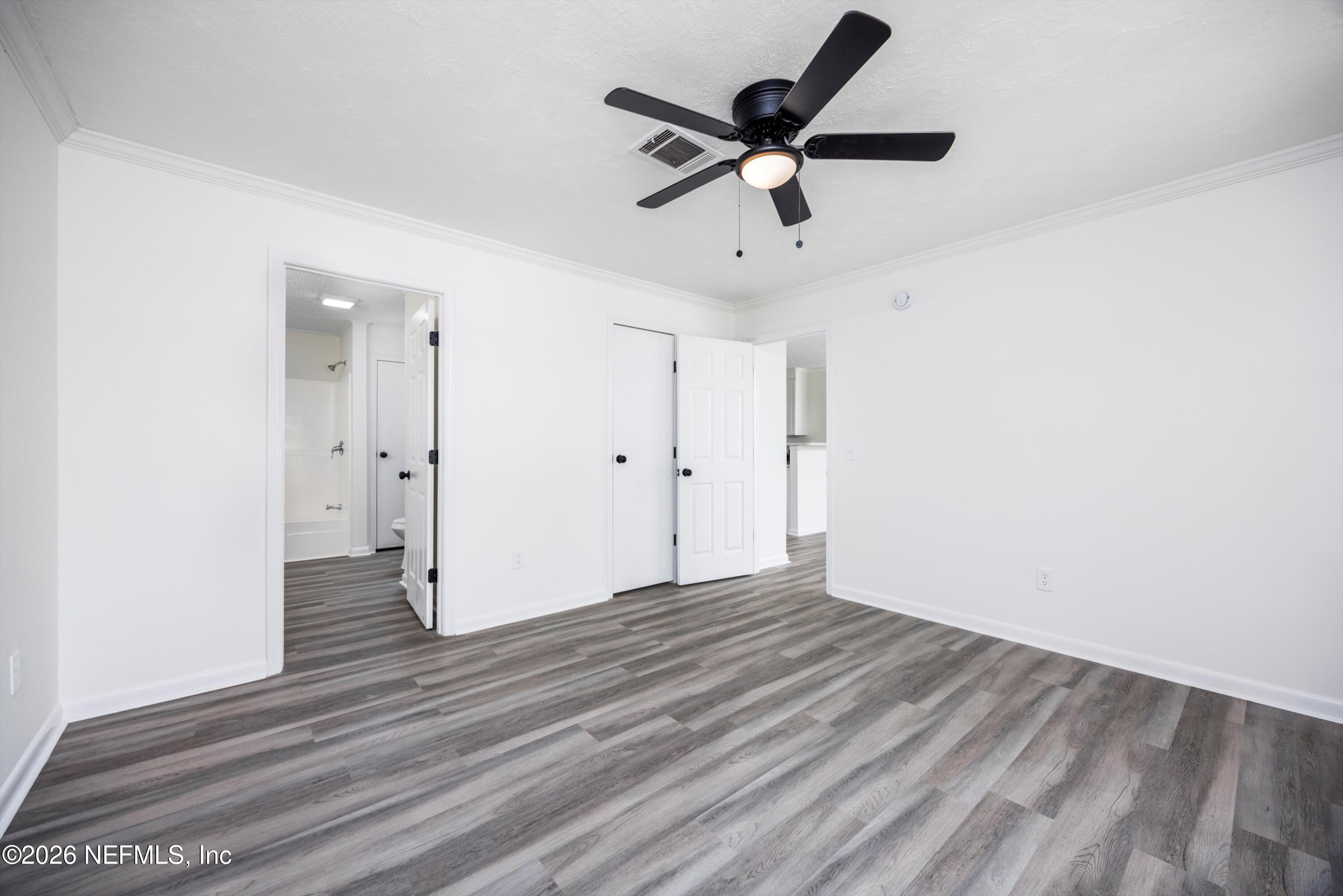 900 Helen Street St. Augustine, FL 32084 - Photo 13 of 31 an empty room with wooden floor and a ceiling fan
