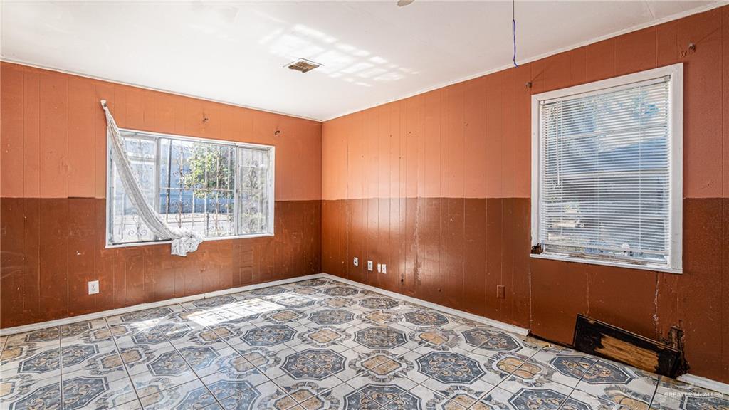 610 West Pike Boulevard Weslaco, TX 78596 - Photo 9 of 15 Unfurnished room with wooden walls, wainscoting, and ornamental molding