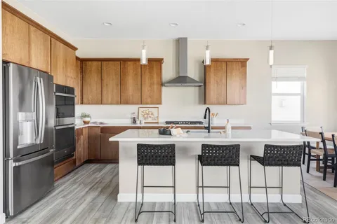 a kitchen with granite countertop a refrigerator stove top oven and sink