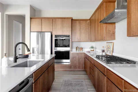 a kitchen with kitchen island granite countertop a sink stainless steel appliances and cabinets