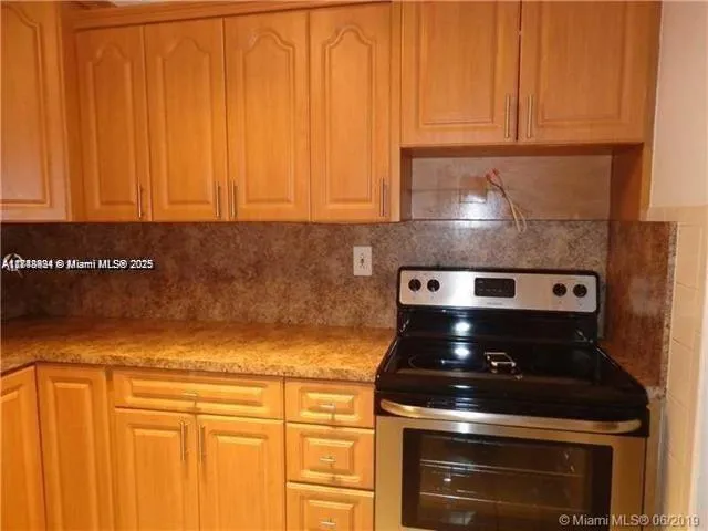 a stove top oven sitting inside of a kitchen