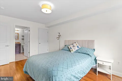 a bedroom with a bed and painting on the wall