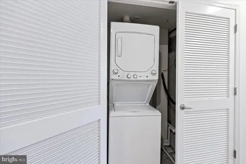a view of a hallway with wooden floor and a bathroom