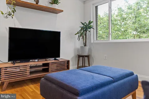 a large kitchen with stainless steel appliances a large counter top a stove and a refrigerator with wooden floor