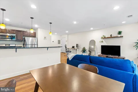 a living room with furniture and a wooden floor