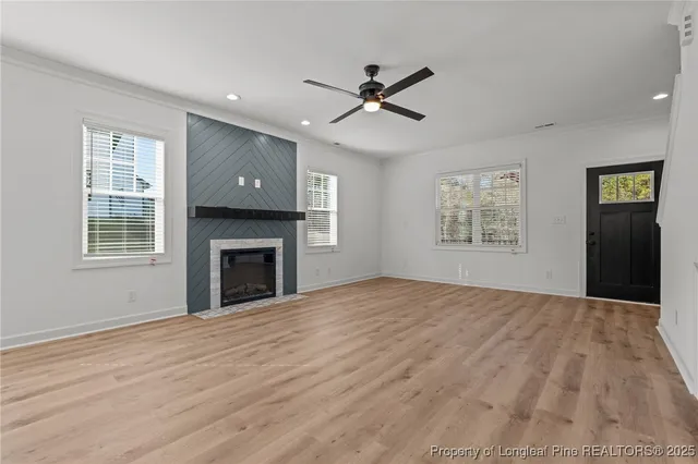 a kitchen with stainless steel appliances a sink dishwasher a refrigerator a stove and white cabinets with wooden floor