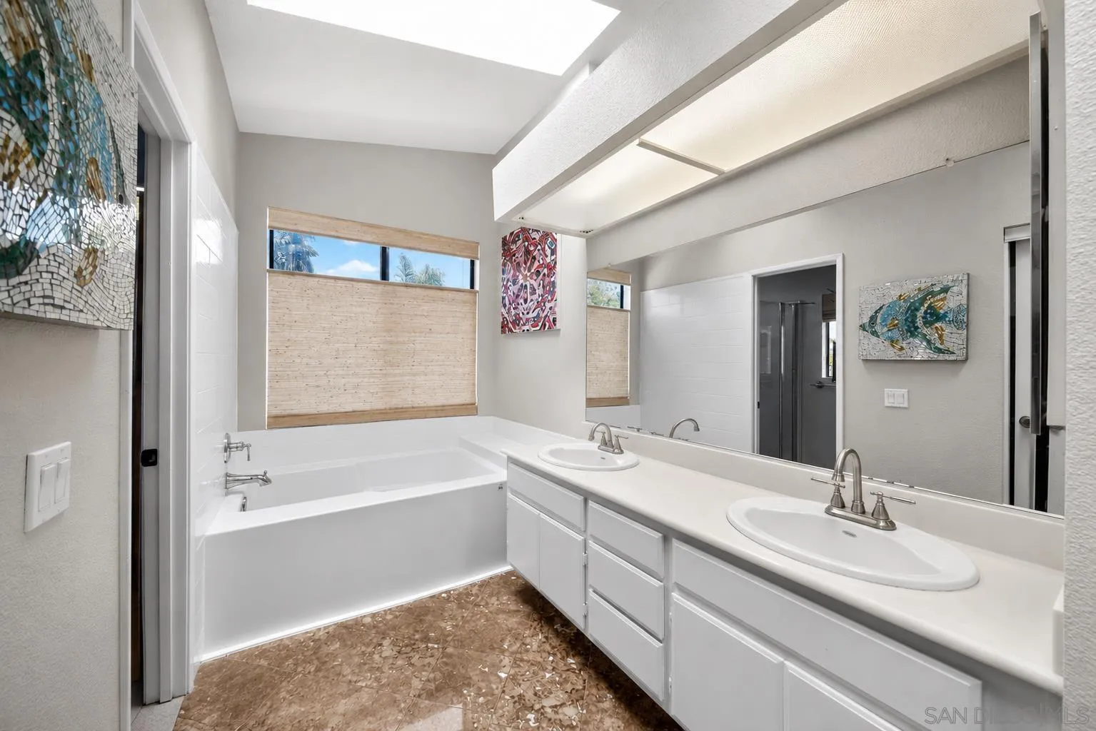 5287 Rio Plata Drive Oceanside, CA 92057 - Photo 11 of 38 a bathroom with a two sinks a large mirror and a bathtub next to a window
