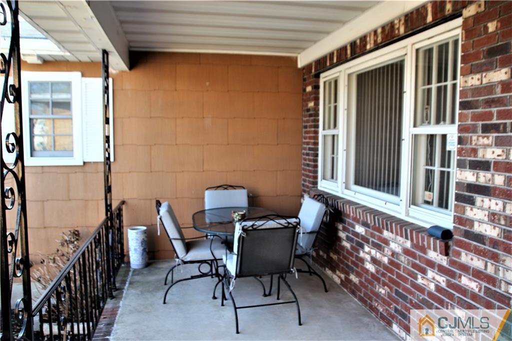 75 Rodak Circle Edison, NJ 08817 - Photo 3 of 32 a view of a patio with table and chairs and wooden floor