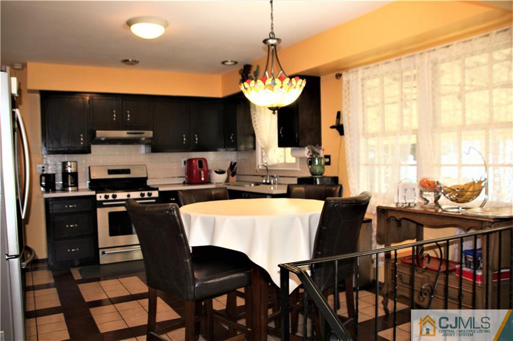 75 Rodak Circle Edison, NJ 08817 - Photo 8 of 32 a kitchen with a dining table chairs and stove