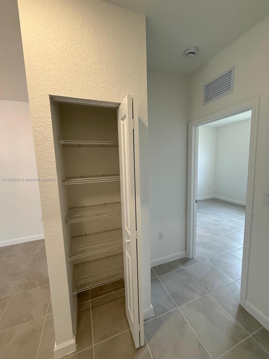 2942 Southeast 23rd Avenue Homestead, FL 33035 - Photo 12 of 20 a view of walk in closet with empty racks