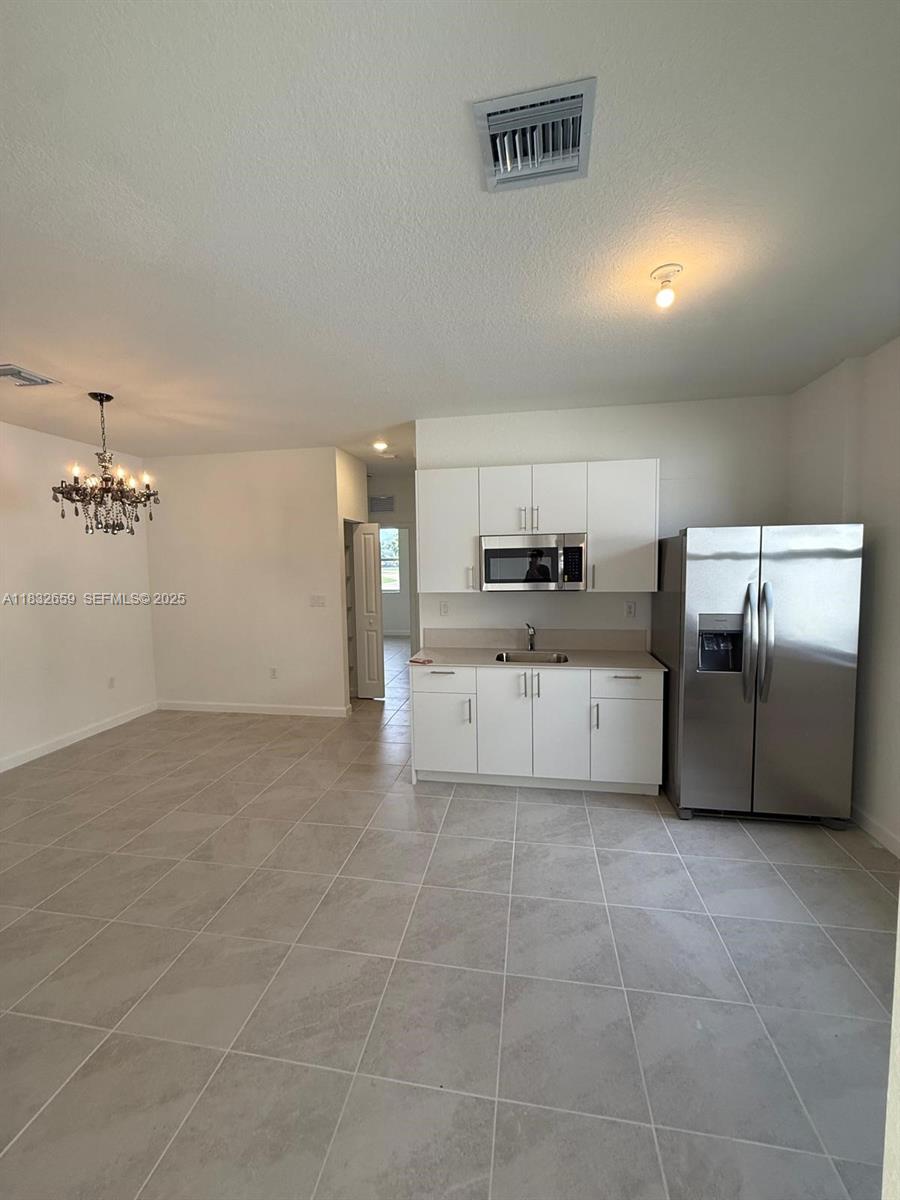 2942 Southeast 23rd Avenue Homestead, FL 33035 - Photo 4 of 20 a large kitchen with cabinets and stainless steel appliances