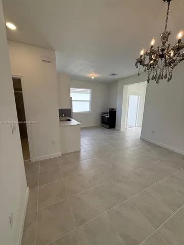 an empty room with mirror and a sink