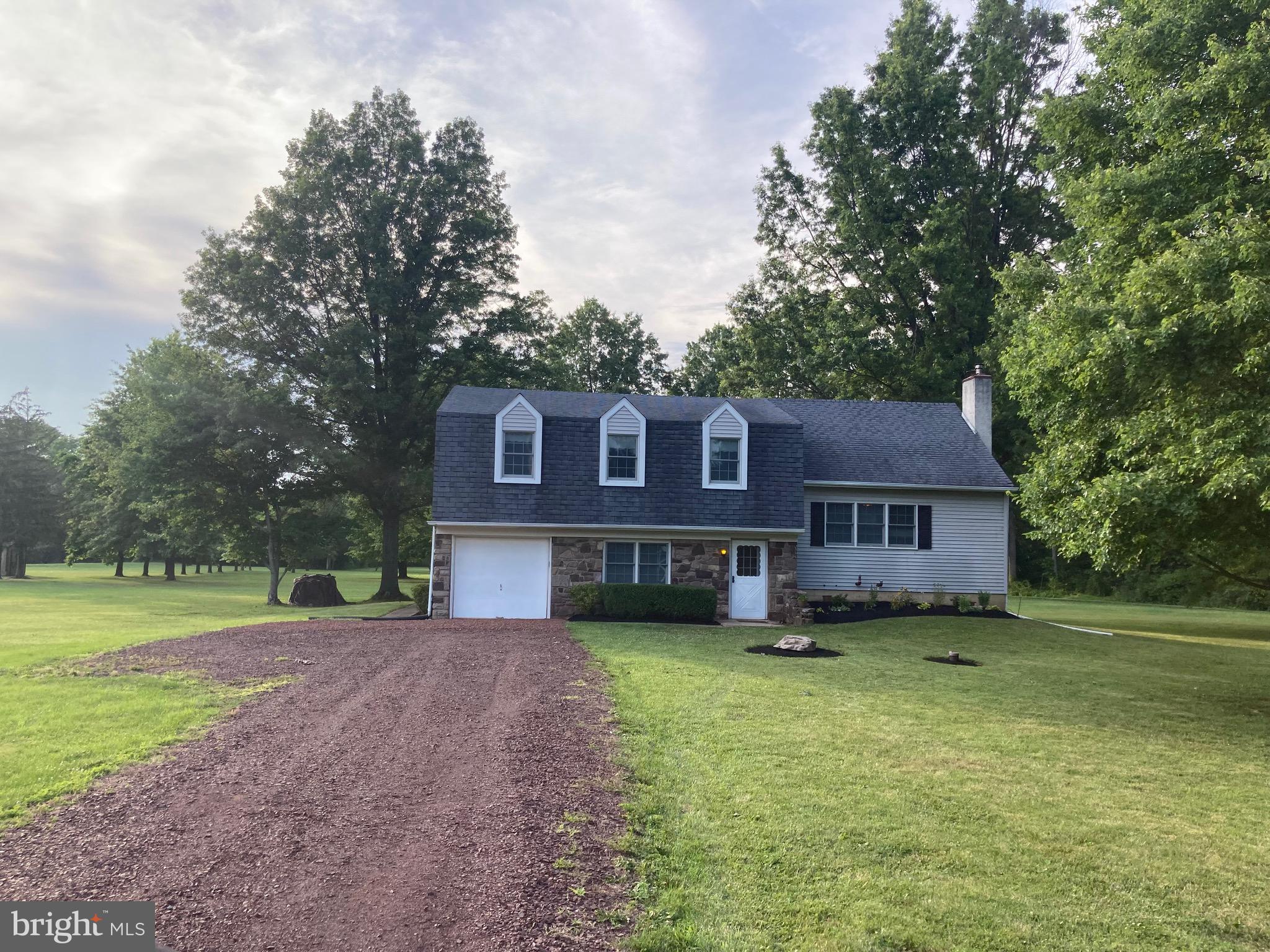5791 Stump Road Pipersville, PA 18947 - Photo 2 of 4 a view of a yard in front of a house with large trees