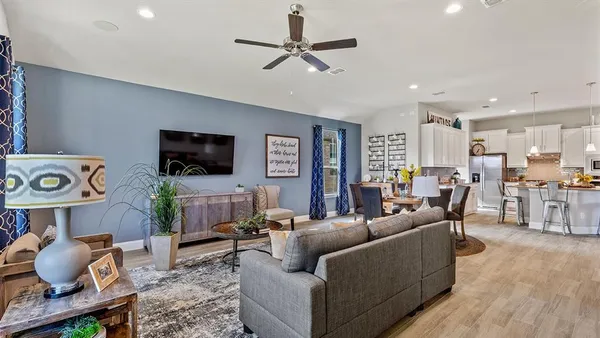 a living room with furniture a flat screen tv and a large window
