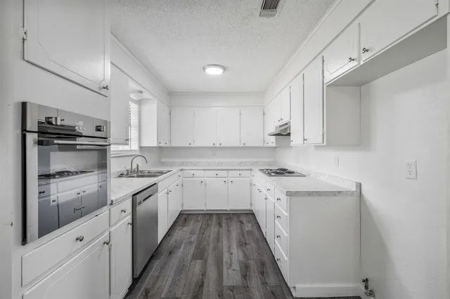 a kitchen with granite countertop white cabinets and white appliances