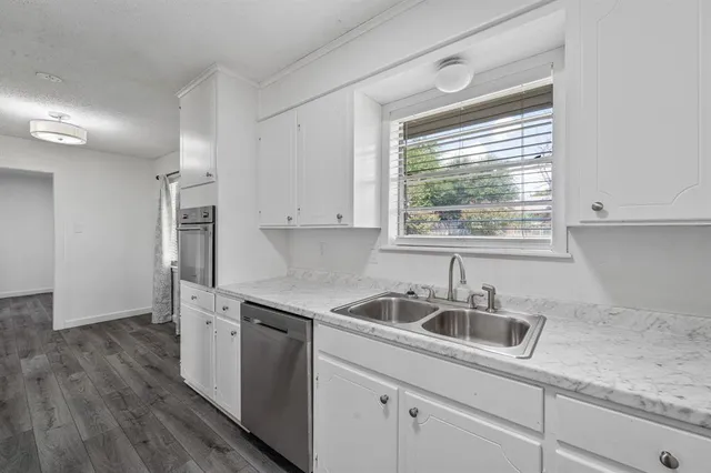 a kitchen that has a sink cabinets counter space and a window