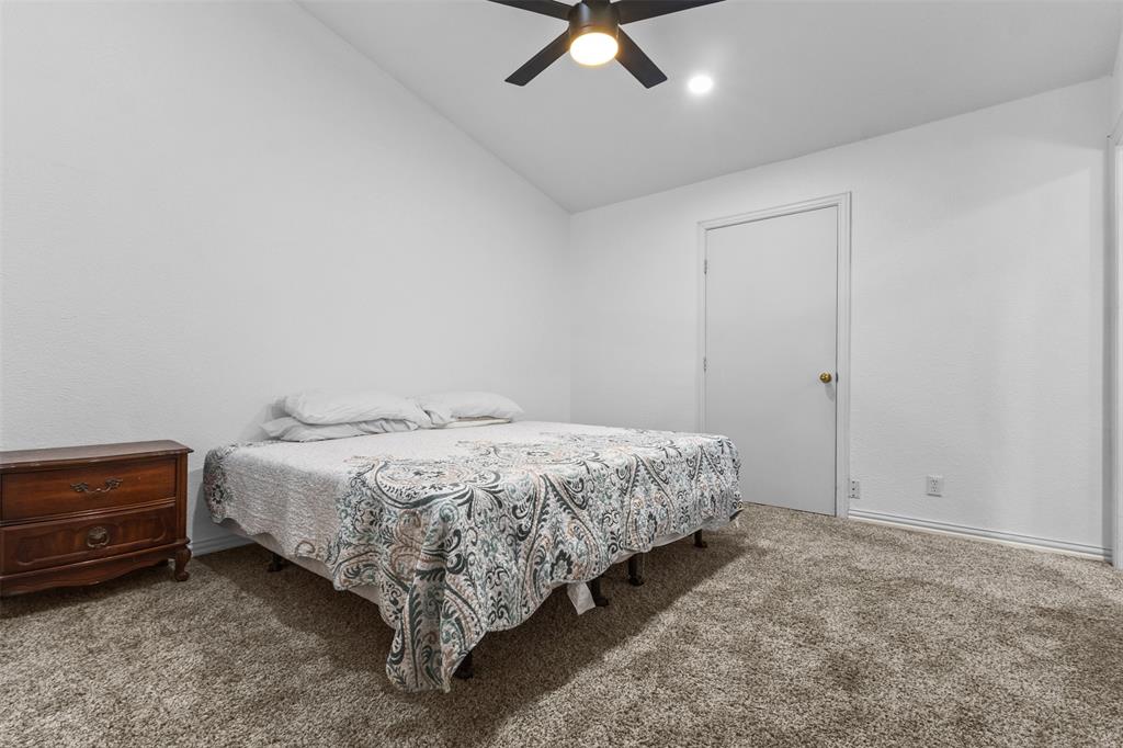 1108 Blackland Road Fate, TX 75189 - Photo 12 of 28 a spacious bedroom with a bed and a chandelier