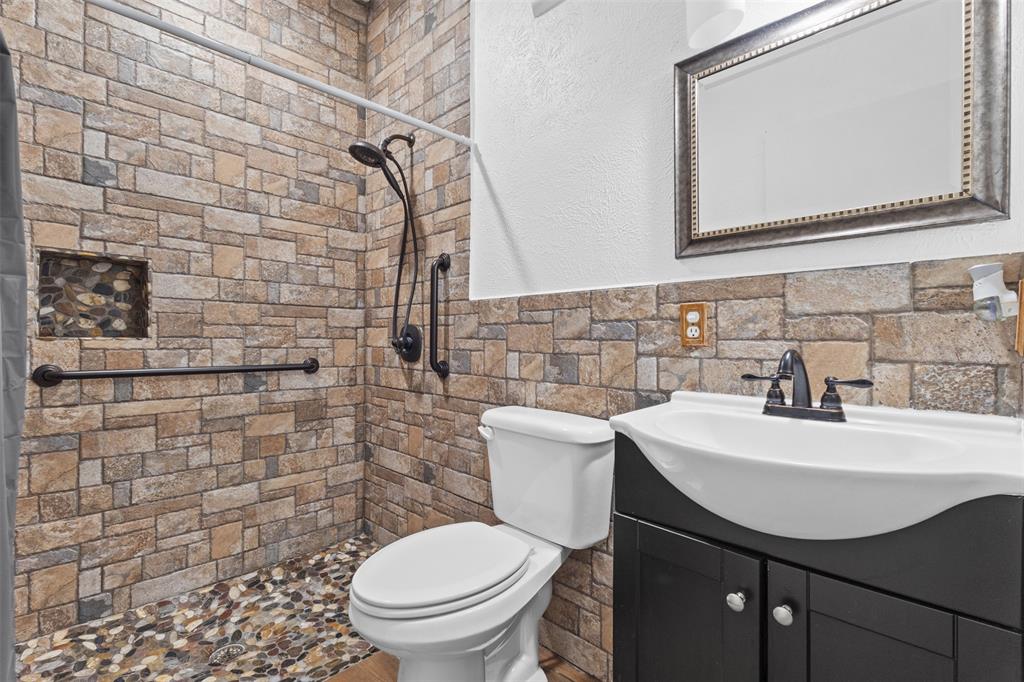 1108 Blackland Road Fate, TX 75189 - Photo 13 of 28 a bathroom with a sink a toilet and mirror