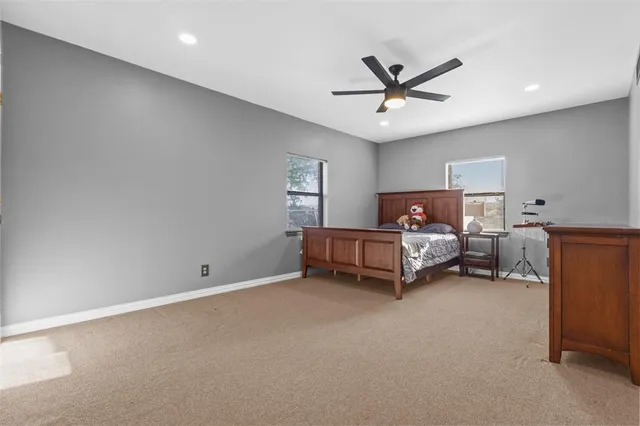 en empty room with windows and ceiling fan