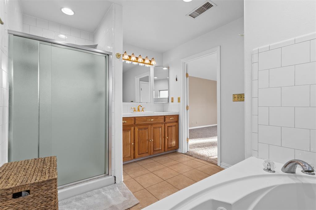 1108 Blackland Road Fate, TX 75189 - Photo 20 of 28 a bathroom with a shower sink and a mirror