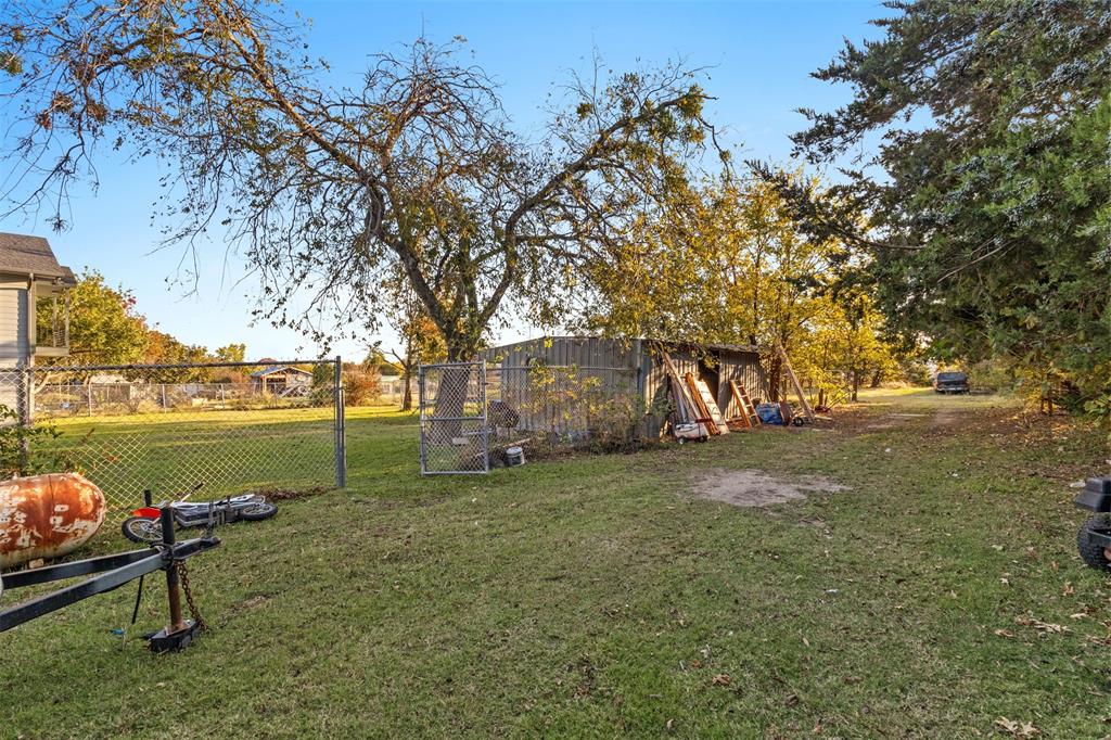 1108 Blackland Road Fate, TX 75189 - Photo 25 of 28 a view of a lake with a bench and trees around