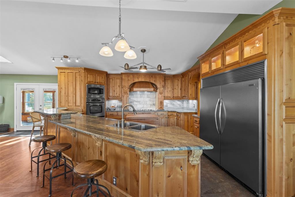 1108 Blackland Road Fate, TX 75189 - Photo 3 of 28 a kitchen with stainless steel appliances granite countertop a sink a stove and a refrigerator