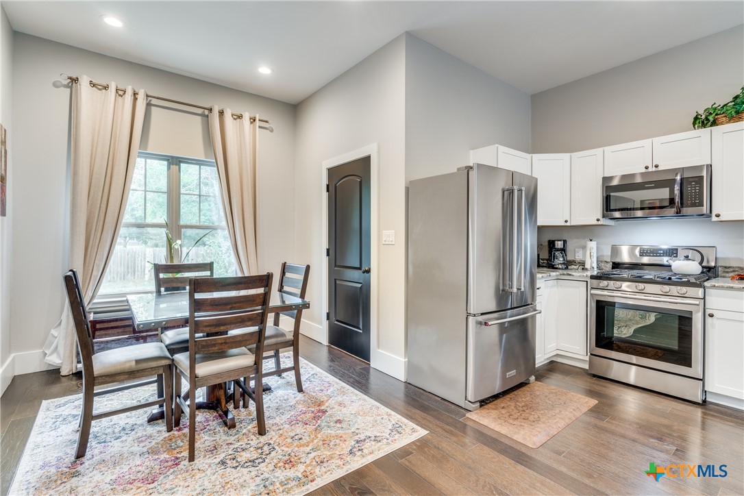 911 Farm Street Bastrop, TX 78602 - Photo 32 of 40 a kitchen with granite countertop a refrigerator and a stove top oven