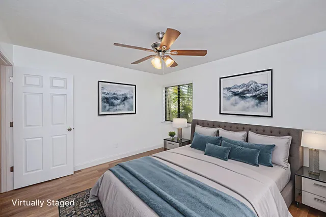 a bedroom with bed and two large window