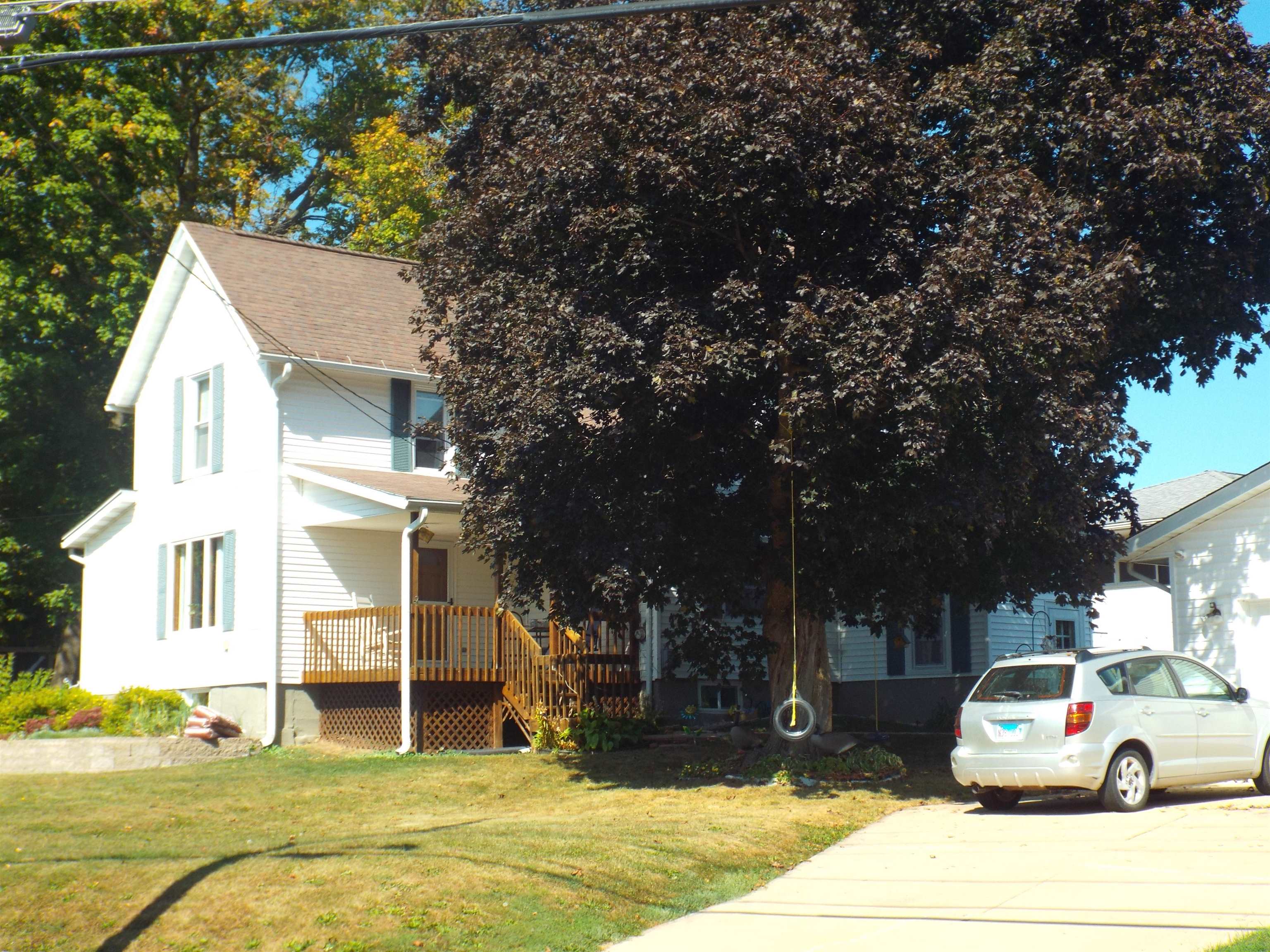 a white house that has a tree in front of it