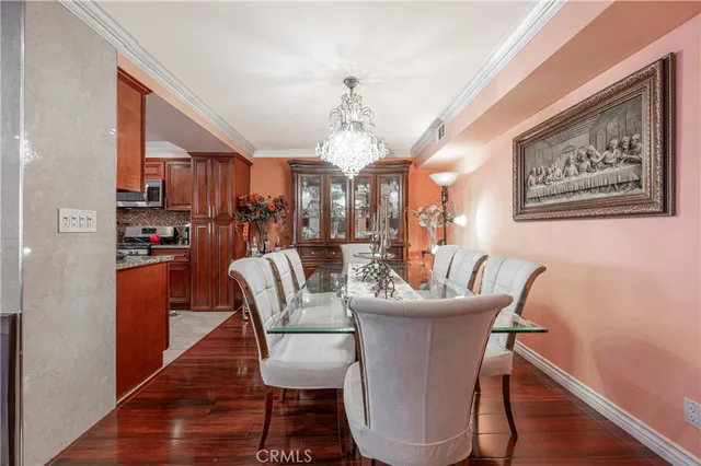 a dining room with furniture a chandelier and wooden floor