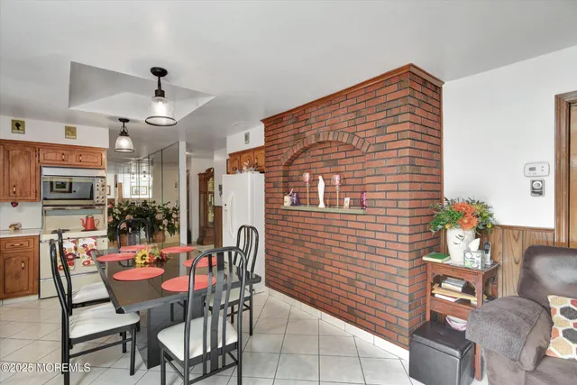 a view of a dining room with furniture a kitchen and chandelier