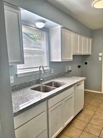 a kitchen with granite countertop a sink and a window