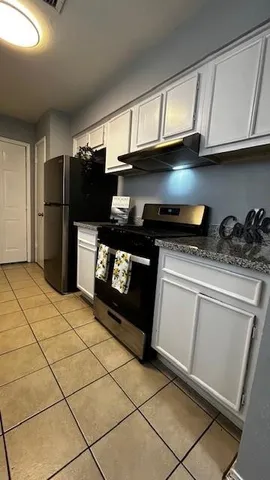 a kitchen with stainless steel appliances a stove a refrigerator and cabinets
