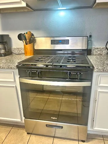 a stove top oven sitting inside of a kitchen