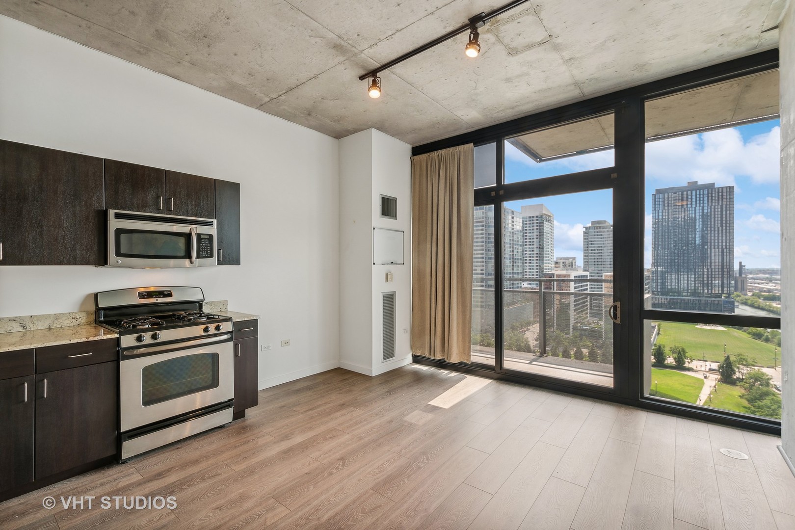 235 West Van Buren Street, Unit 1809 Chicago, IL 60607 - Photo 5 of 13 a kitchen with stainless steel appliances granite countertop a stove a sink and a refrigerator