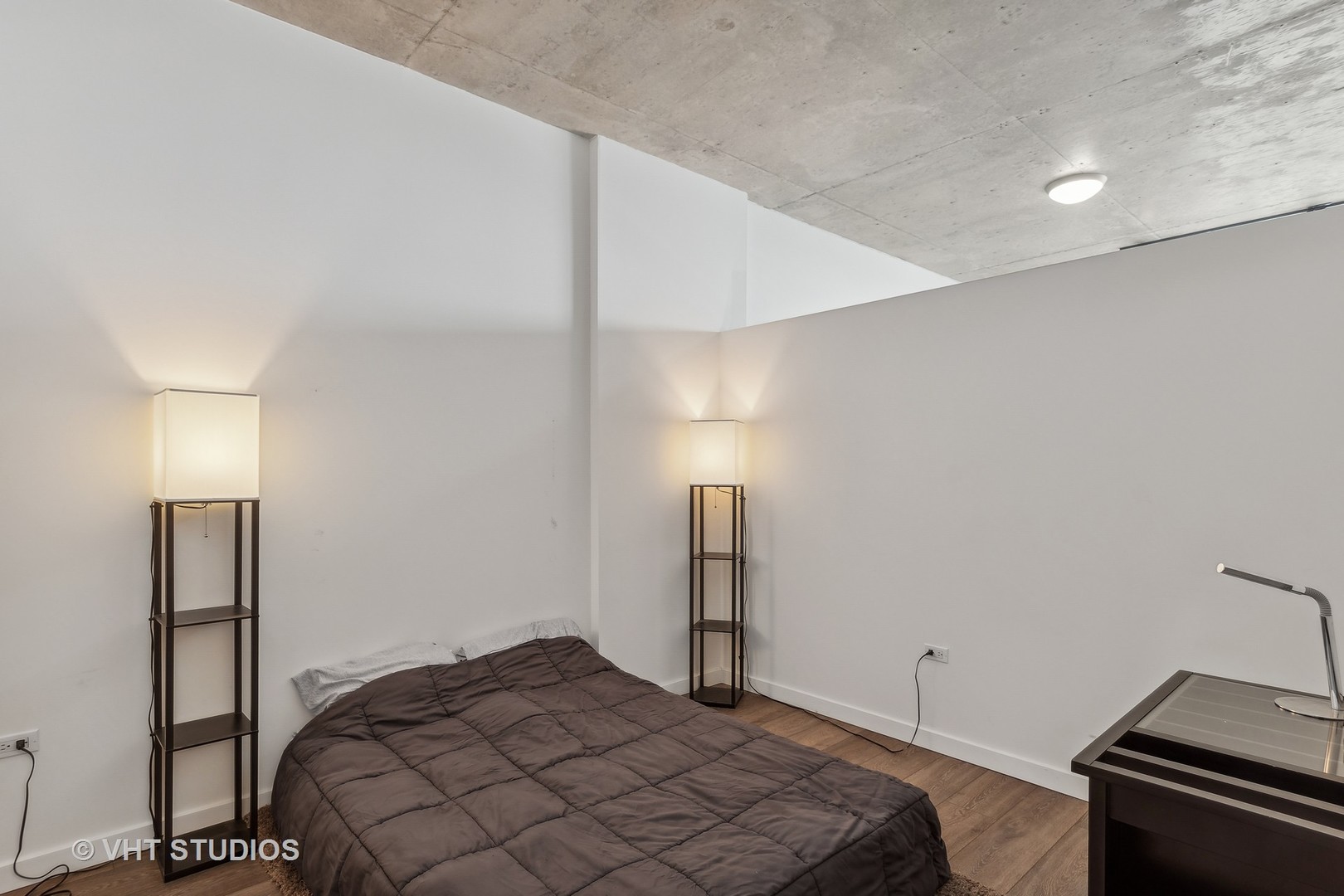 235 West Van Buren Street, Unit 1809 Chicago, IL 60607 - Photo 9 of 13 a bedroom with a bed and a lamp on the dresser