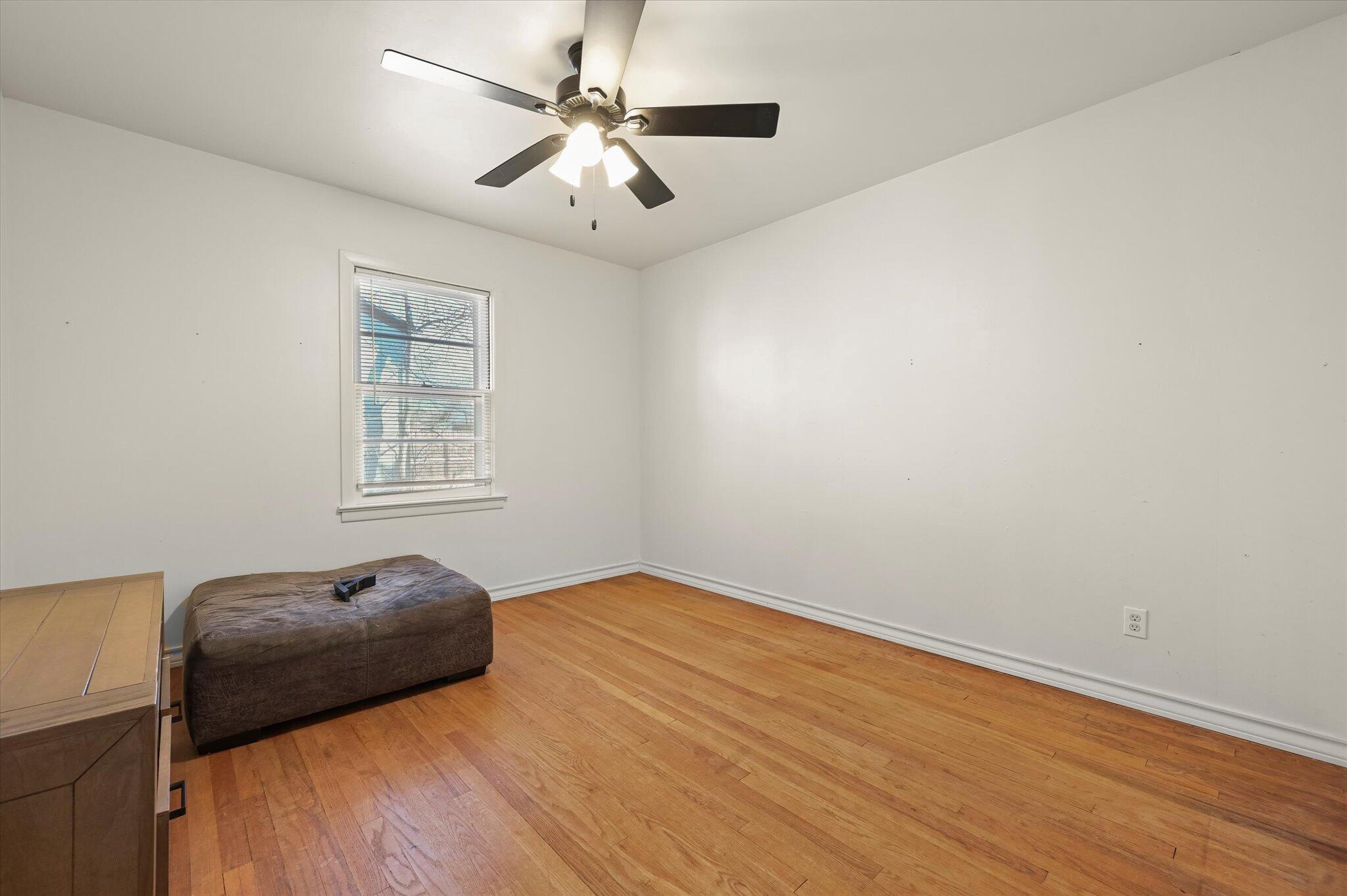 3707 25th Street Lubbock, TX 79410 - Photo 17 of 29 wooden floor in an empty room with a window