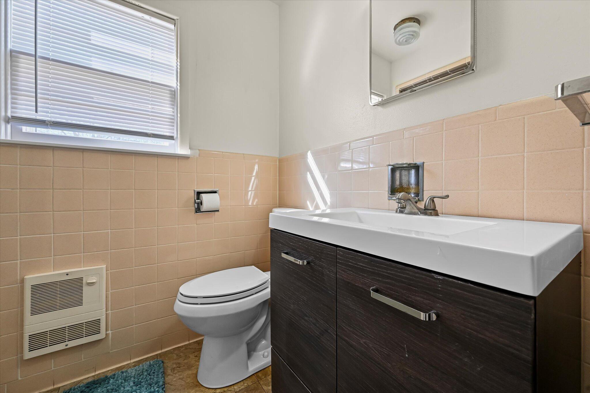 3707 25th Street Lubbock, TX 79410 - Photo 22 of 29 a bathroom with a sink a toilet and a mirror