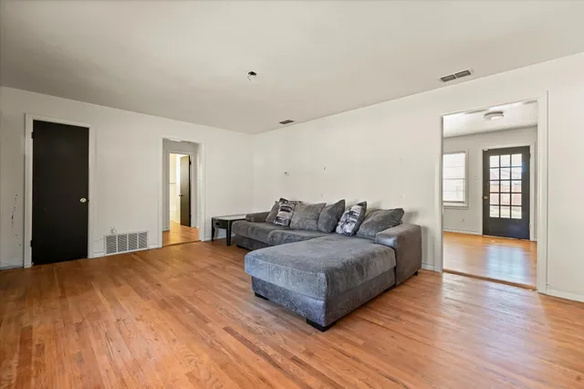 a living room with furniture and wooden floor