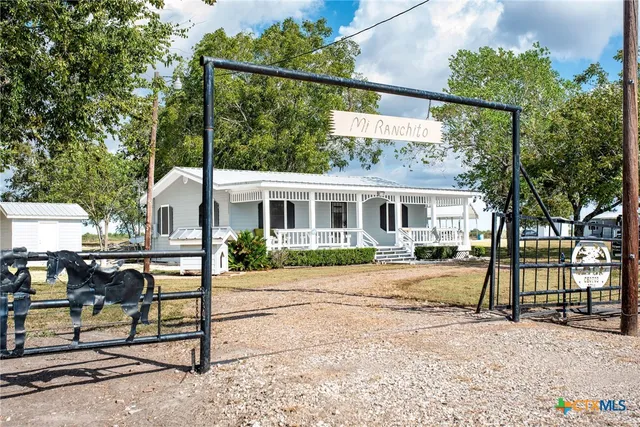 a view of a house with backyard and a tree