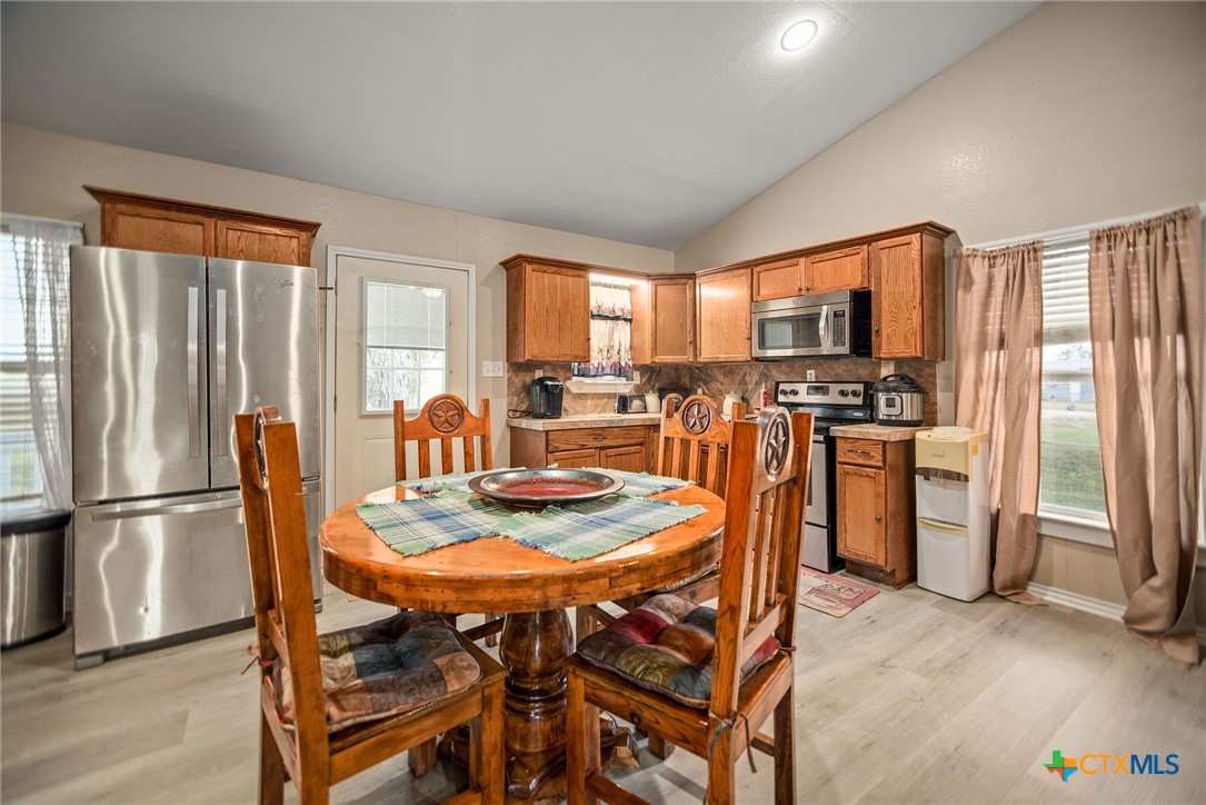 190 Hood Road Inez, TX 77968 - Photo 23 of 36 a dining room with stainless steel appliances furniture a large window and a kitchen view
