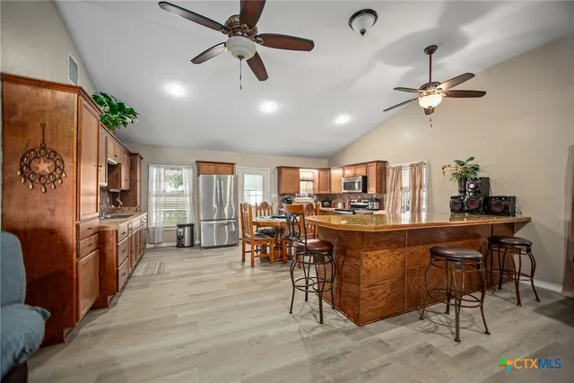 a room with stainless steel appliances lots of wooden furniture