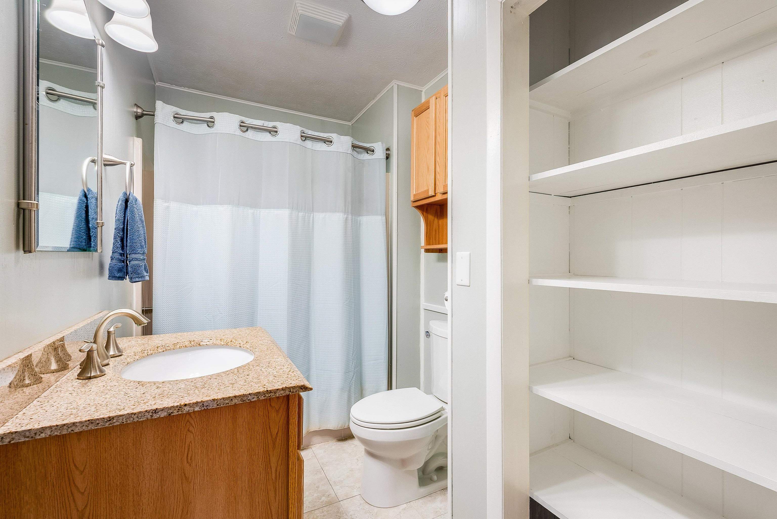 2497 Lacey Spring Road Broadway, VA 22815 - Photo 18 of 45 a bathroom with a granite countertop sink toilet and shower