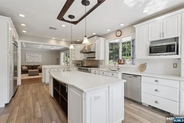 a large kitchen with kitchen island a sink appliances and cabinets